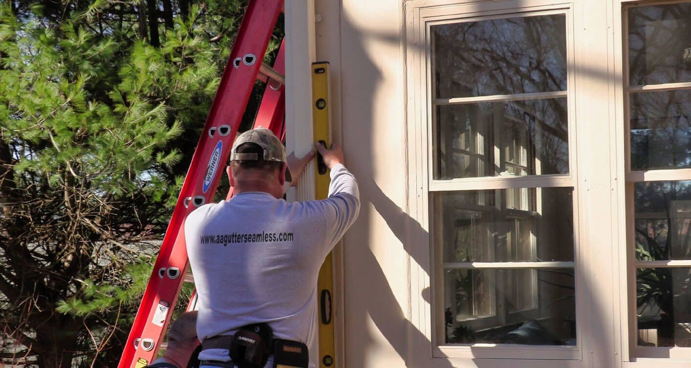 A&A technician using level to ensure perfect gutter alignment